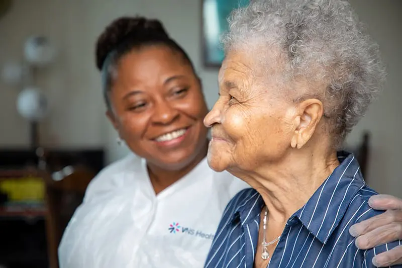 A VNS Health nurse smiling with her patient.