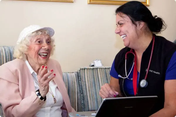 A VNS Health home health aide laughing with her patient.