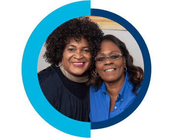 A VNS Health nurse and patient smiling and hugging each other.