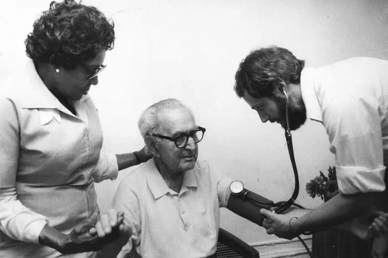 Two VNS Health nurses taking care of a patient during the AIDS epidemic.