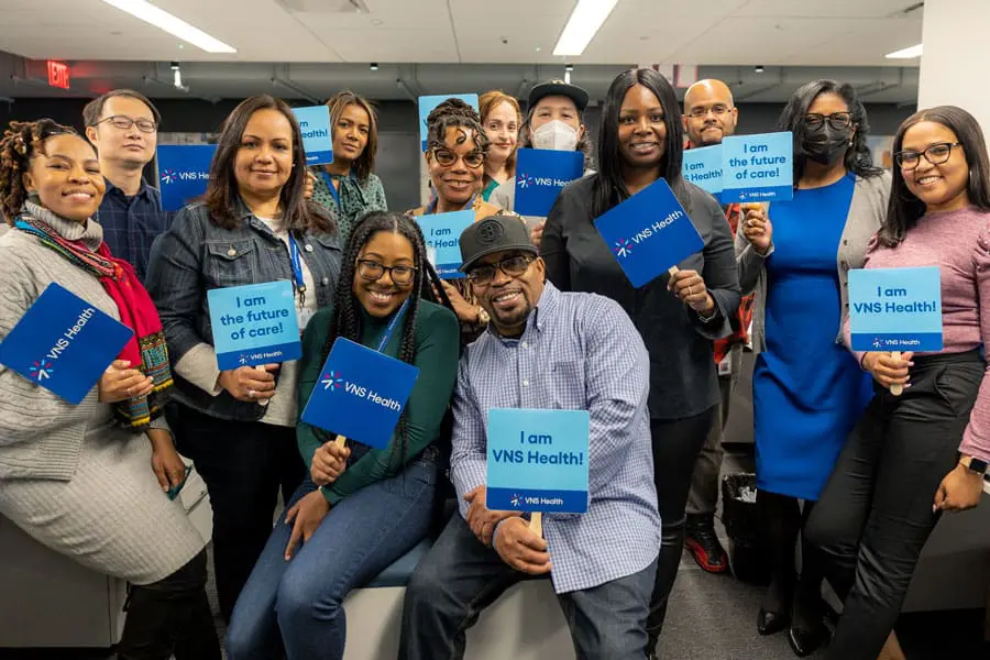 A group of VNS Health team members holding VNS Health signs.