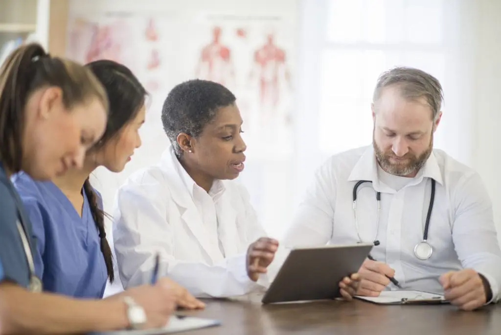 Four VNS Health healthcare providers working together at a conference table.