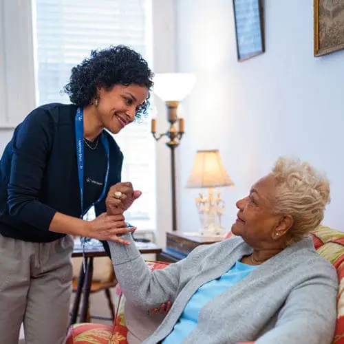 A VNS Health physical therapist helping a patient with arm exercises.