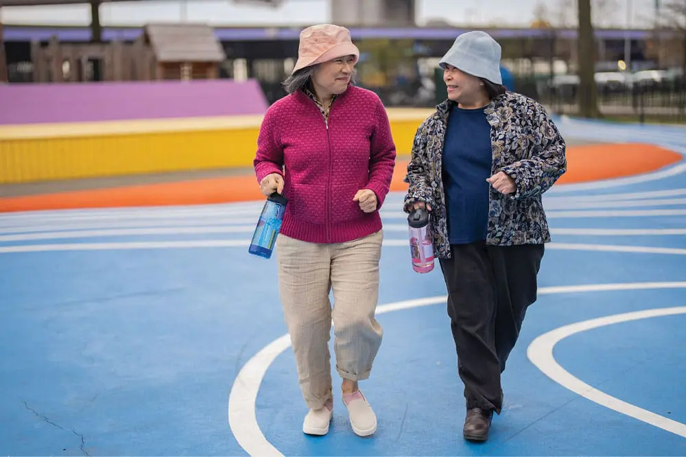 Two friends walking along a track together.
