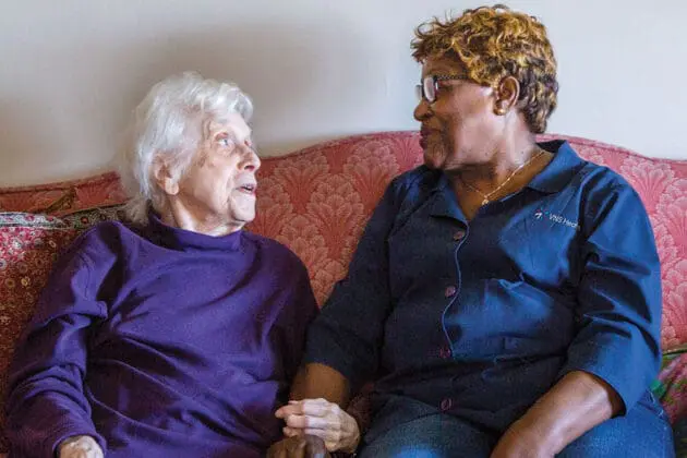 women sitting on a couch talking to each other