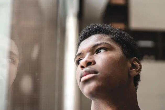 african american man looking up to the side of window