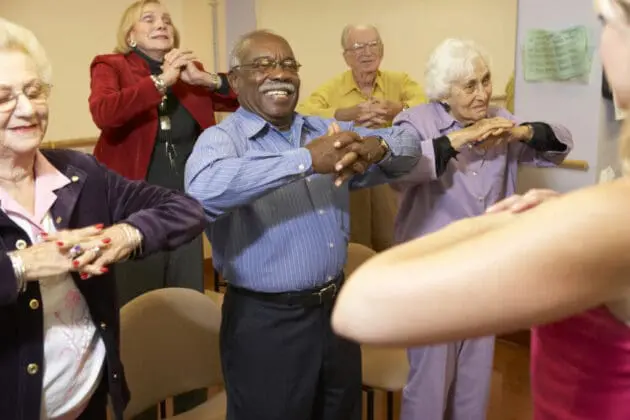 A group of seniors participating in a exercise class.