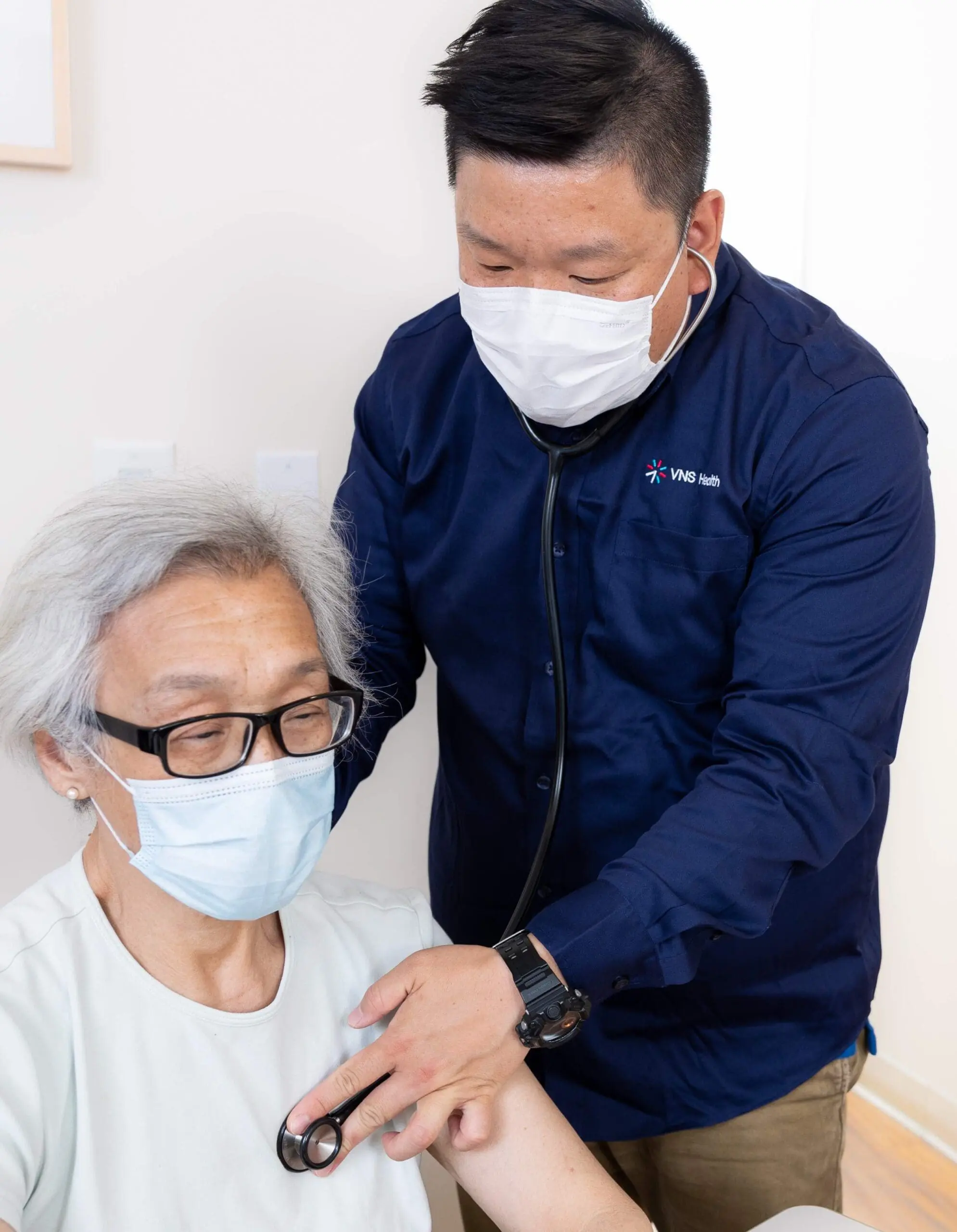 A VNS Health home health aide listening to his patient's heart.
