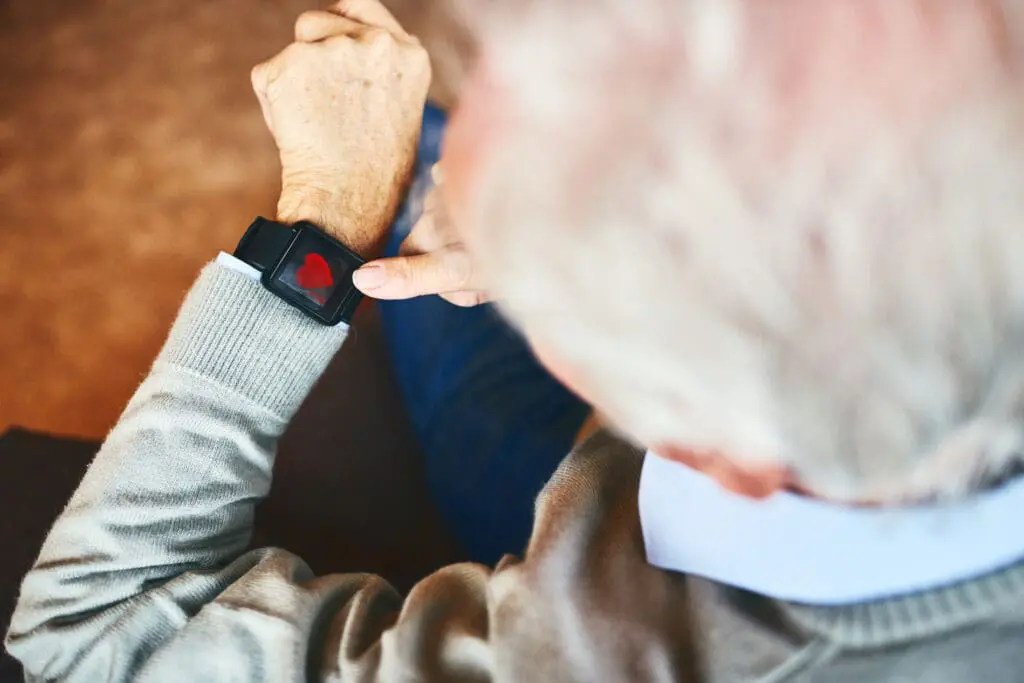 An elderly man monitoring his heart on a smart watch.