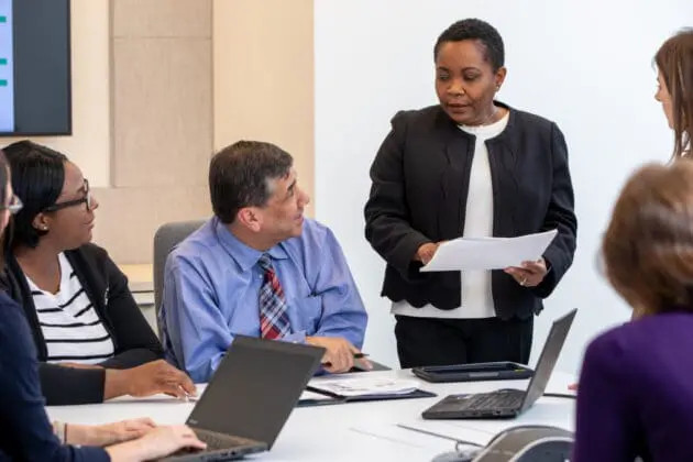 Six VNS Health employees gathered in a meeting to discuss Hospice performance.