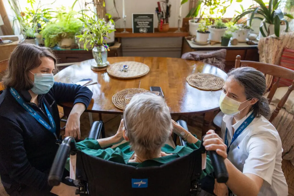 Two VNS Health hospice team members talk with their patient.