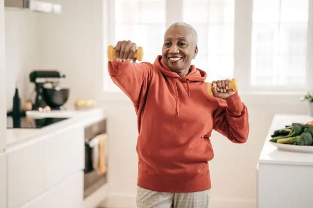 A senior woman exercising in her home.