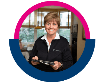 A VNS Health nurse smiles, holding her tablet.