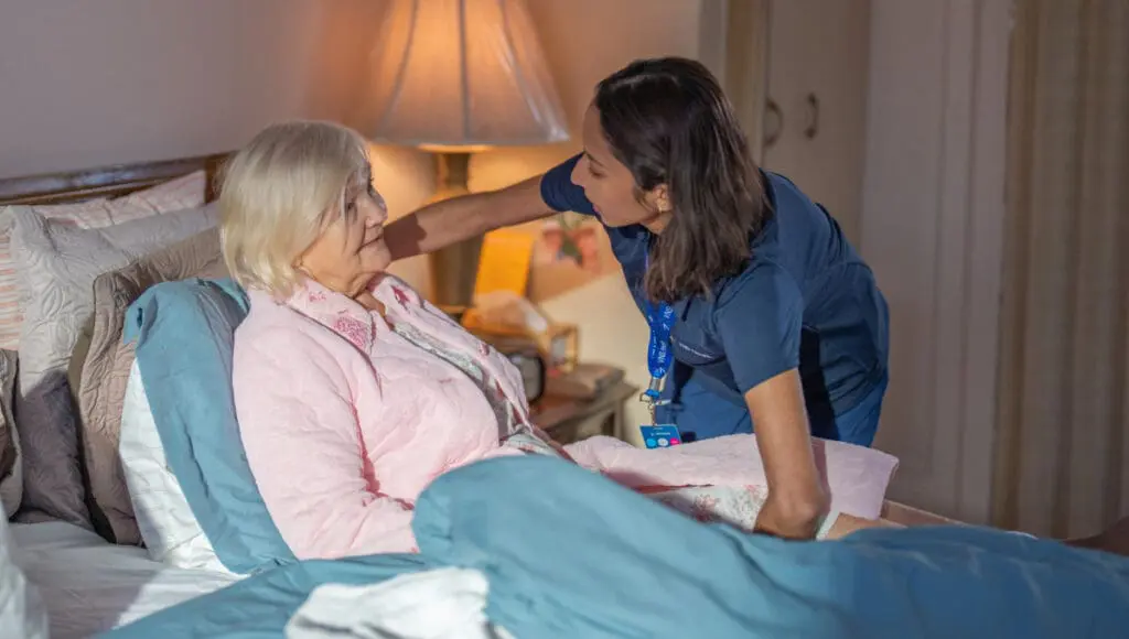 VNS Health team member talking to a hospice patient who is bed-bound.