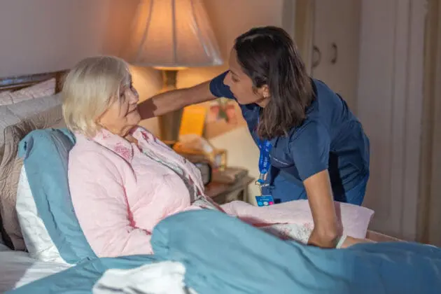 VNS Health team member talking to a hospice patient who is bed-bound.