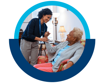 A VNS Health home health aide assisting her elderly patient.