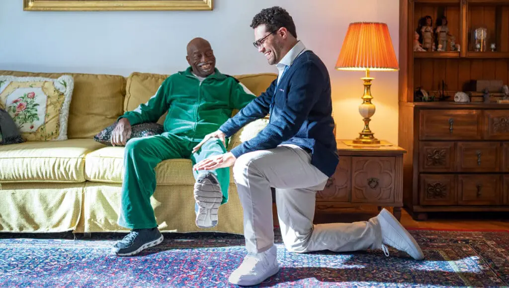 VNS Health physical therapist helping a senior man care for his left foot