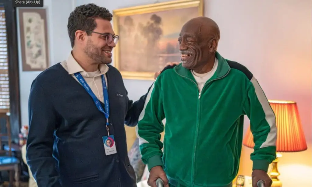 VNS Health team member helping an elderly man walk.