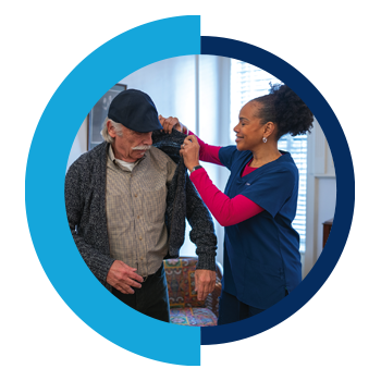 Home Health Aide helping a patient with his sweater.