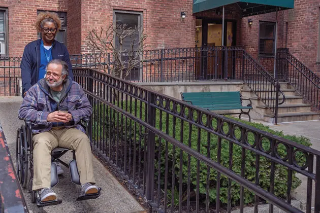 VNS Health Home Health Aide takes patient in wheelchair on a walk.