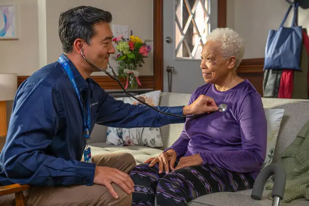 Nurse listens to heartbeat of Smiling patient with stethoscope