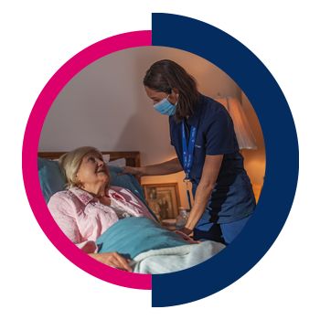Nurse in mask visiting with a bedbound hospice patient.