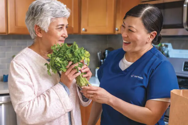 elderly woman and nurse holding herbs