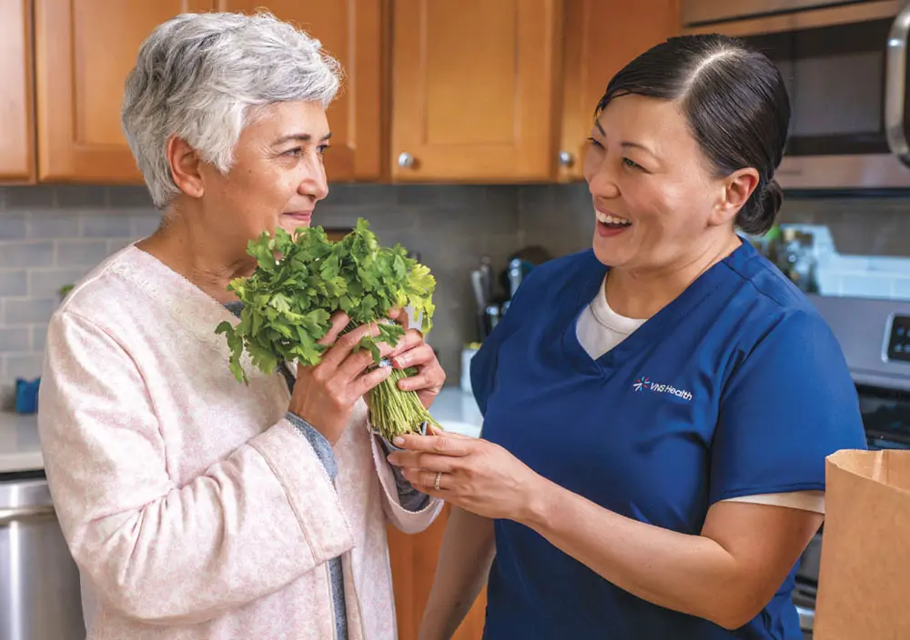 elderly woman and nurse holding herbs