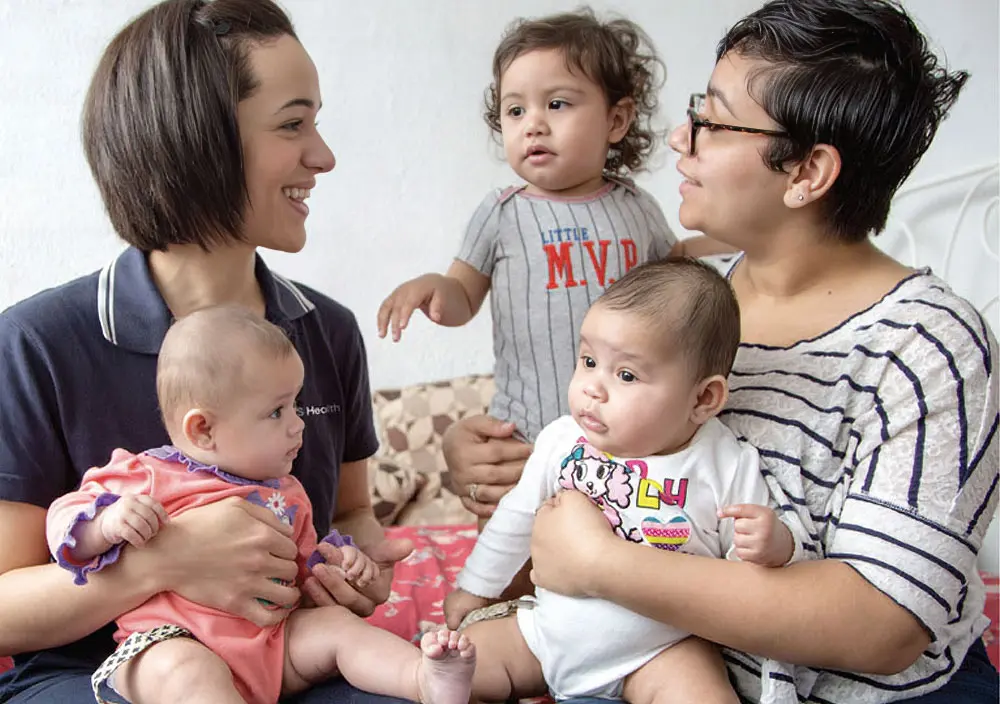 mother and nurse holding babies