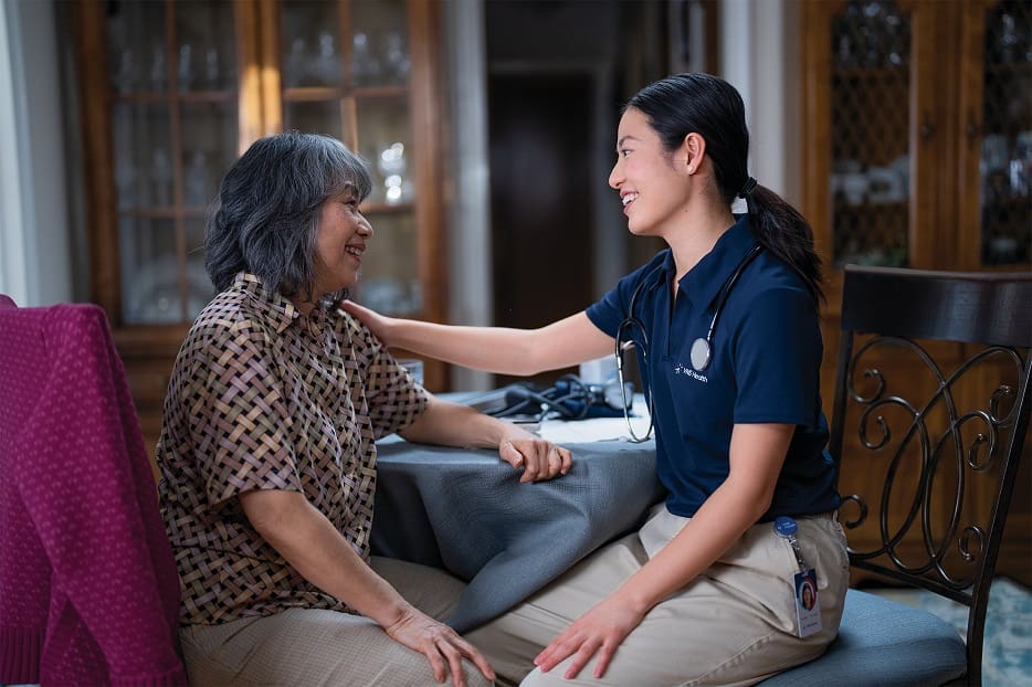 A team member talks with a senior woman.