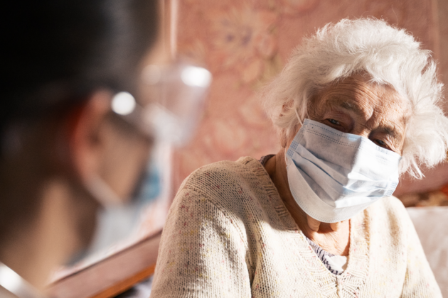 Picture of elderly patient in a mask receiving medical care at home