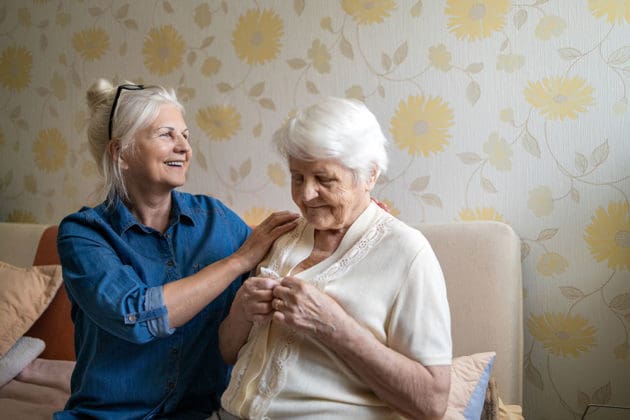 woman with hands on shoulders of elderly woman