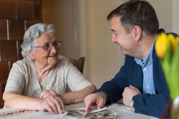 elderly woman and son looking at photos