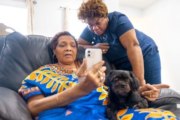 woman holding cell phone nurse looking over her shoulder