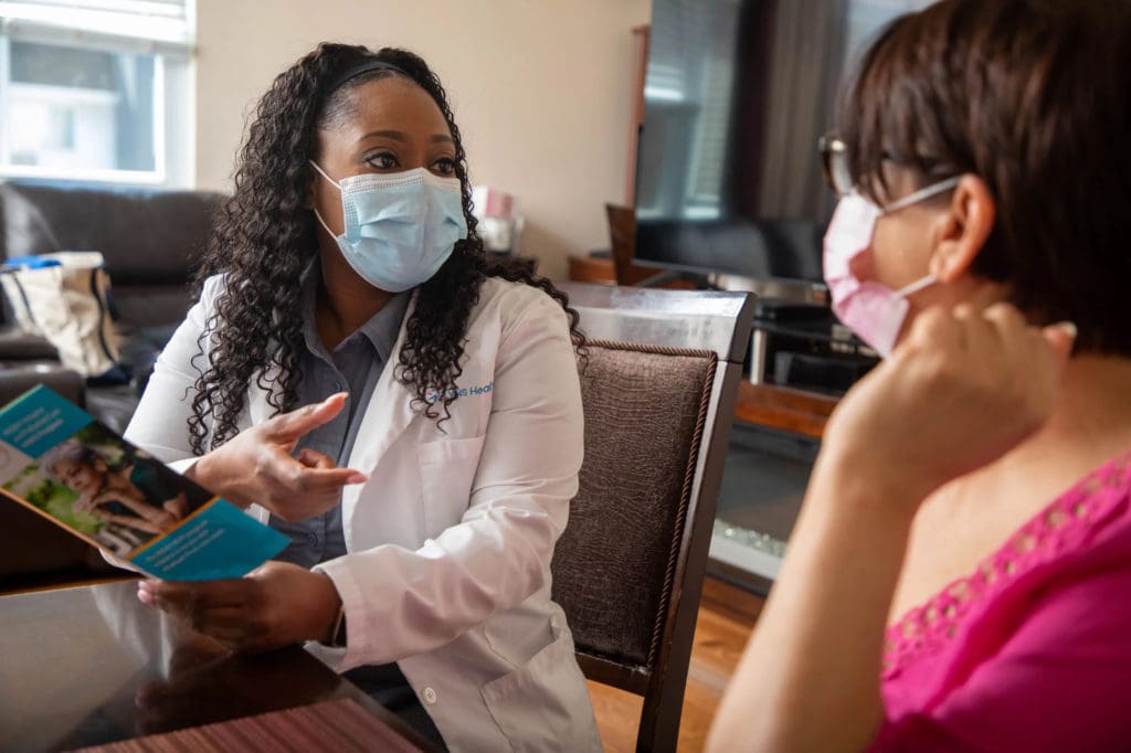 Photo of VNS Health nurse talking with patient