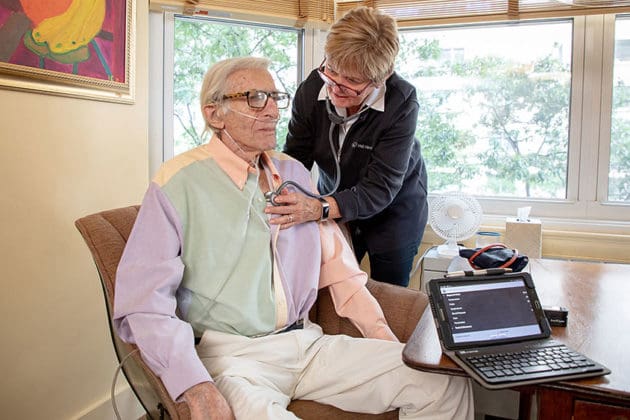 VNS Health home health aide listening to her elderly patient's heart.