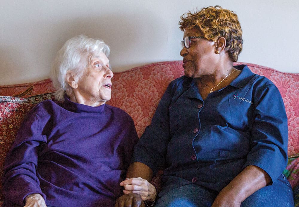 women sitting on a couch talking to each other