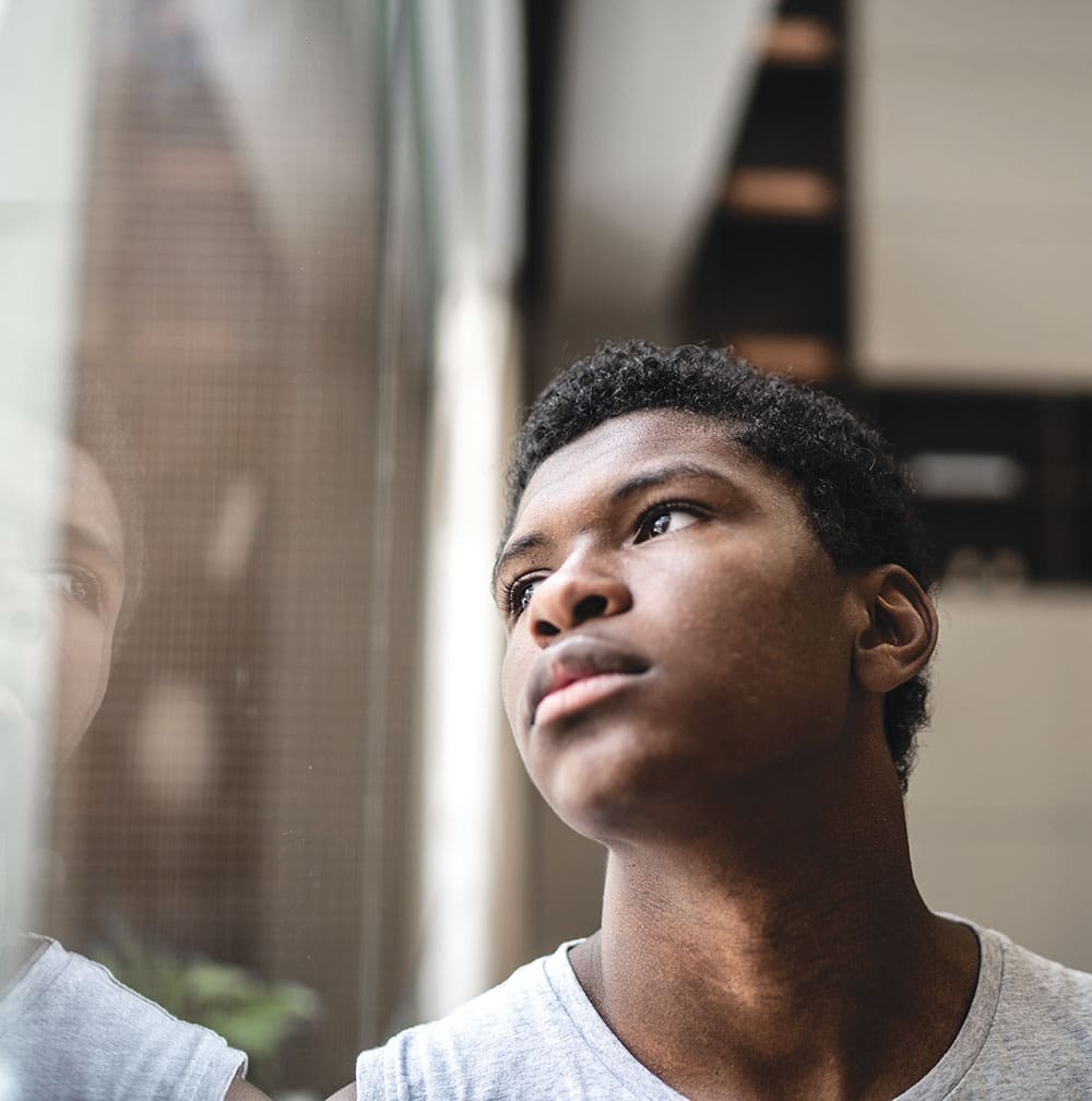 african american man looking up to the side of window