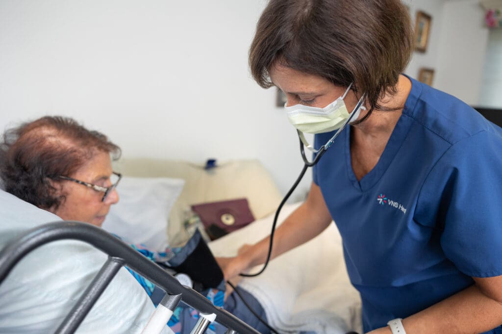 vns health physical therapist checking a patient's blood pressure